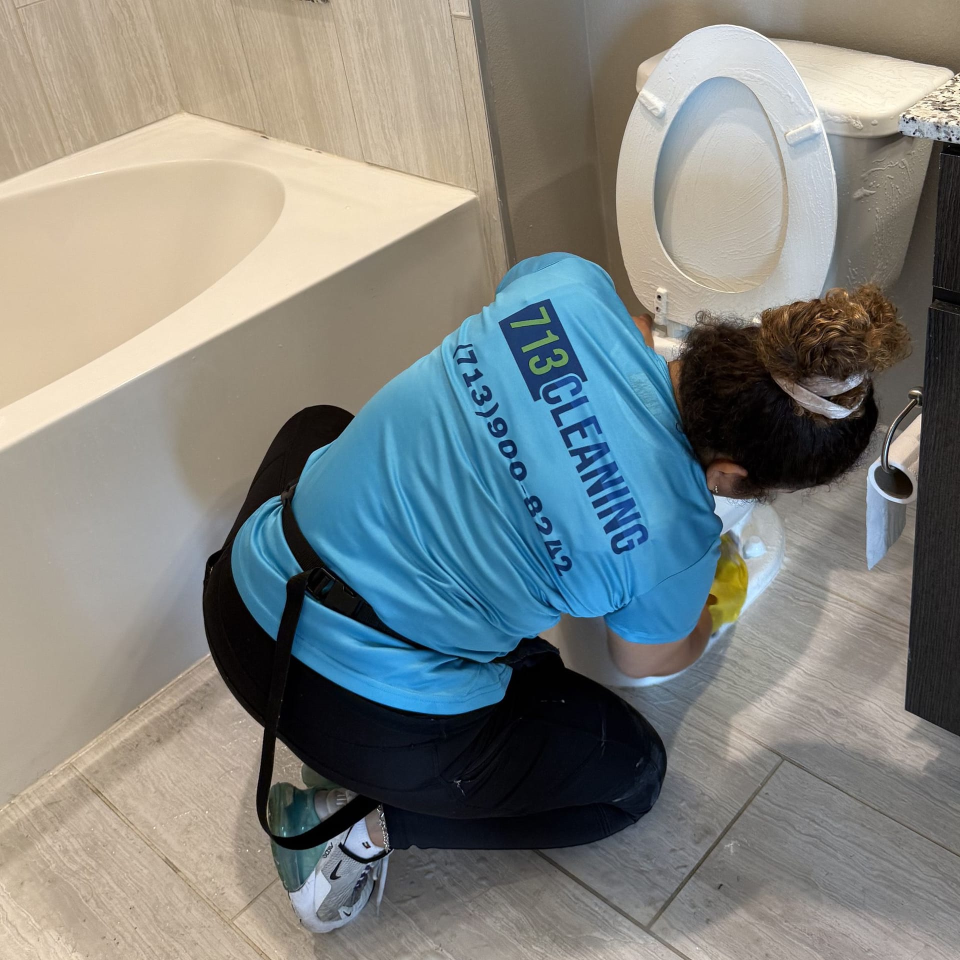 713 Cleaning pro deep-scrubbing a toilet during a deep house cleaning in Katy, TX