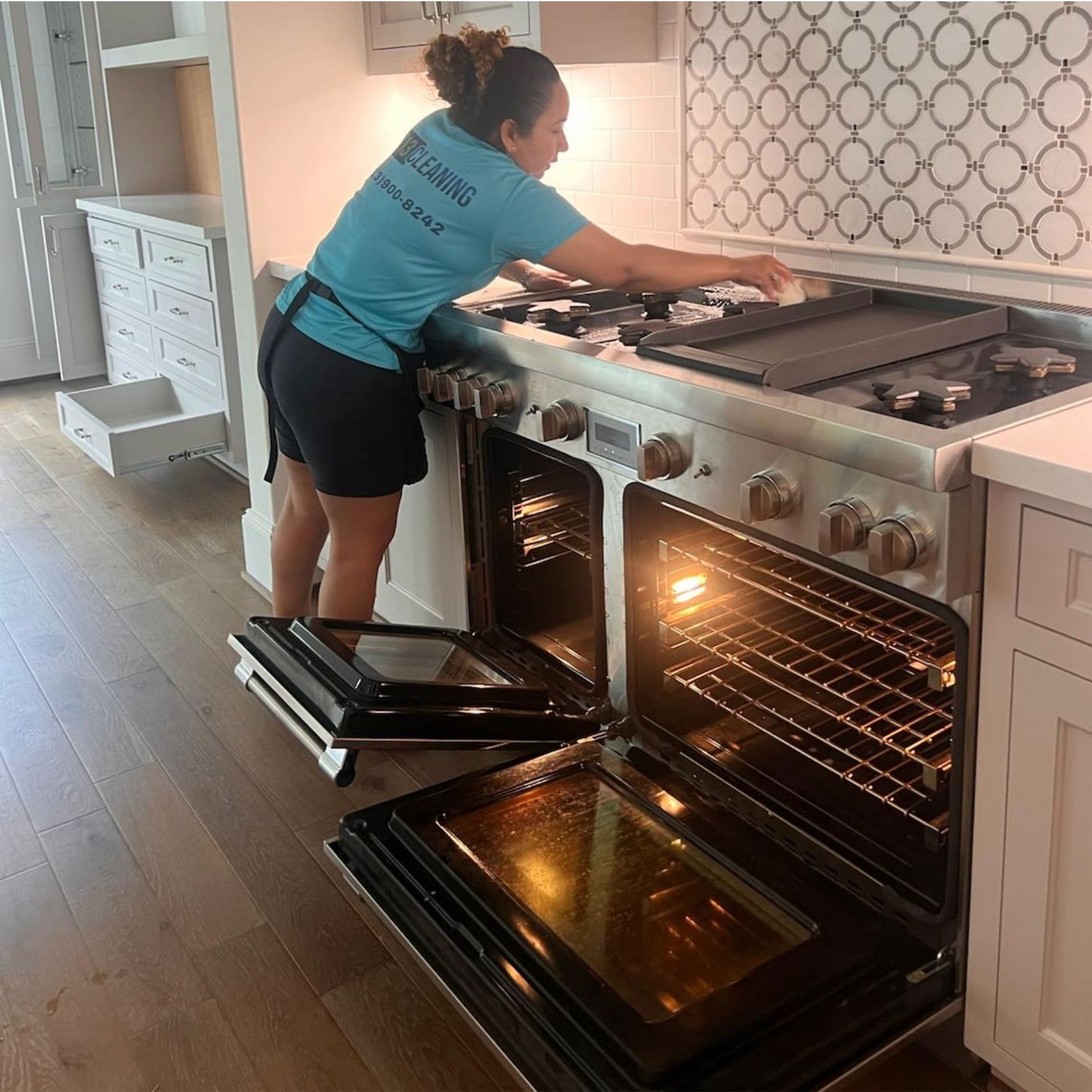 713 Cleaning team member cleaning the stovetop and oven during a house cleaning in Katy, TX