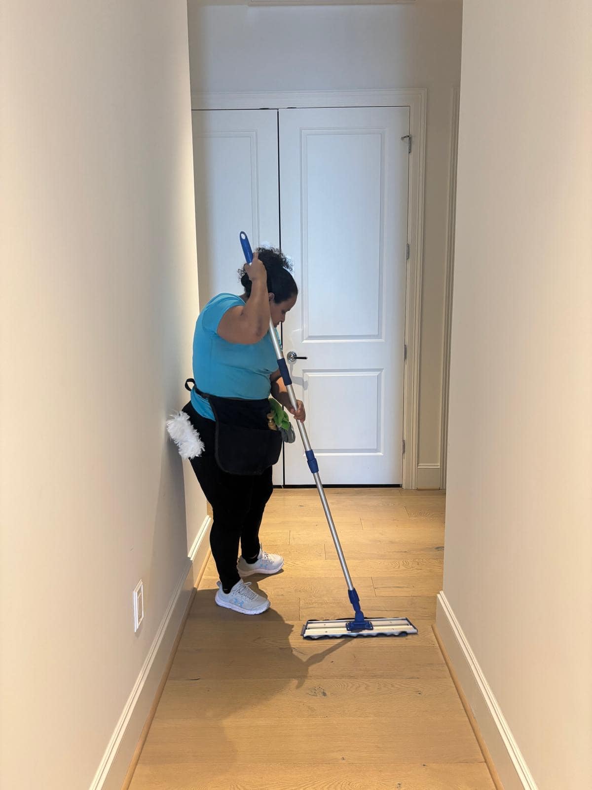 713 Cleaning team member mopping a hallway floor during a recurring house cleaning in a Katy, TX home