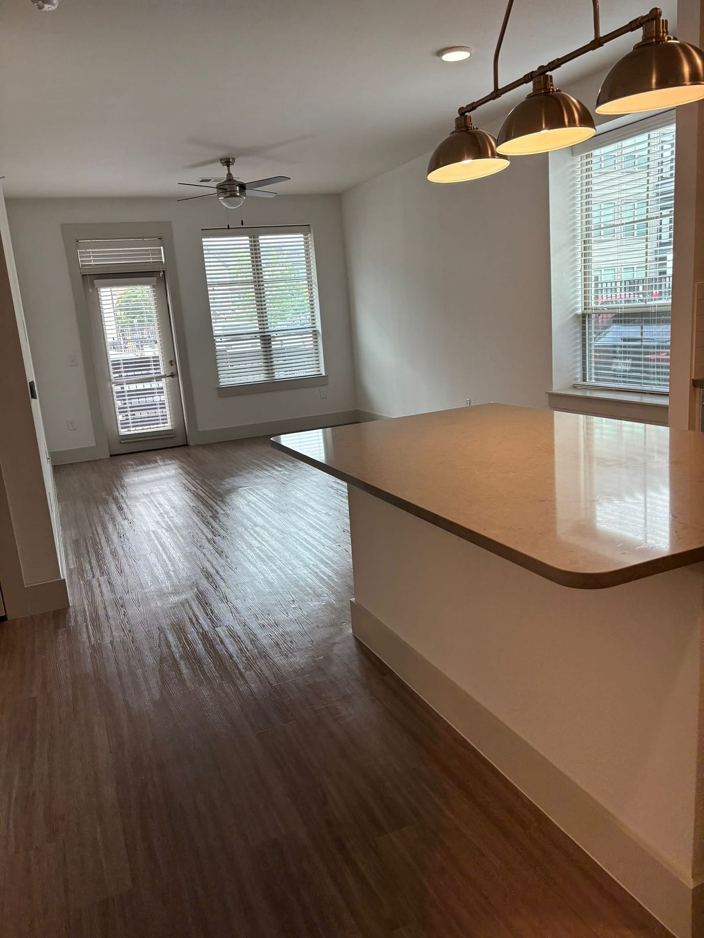 Empty open-plan kitchen and living room with the hardwood floors cleaned, before the furniture arrives.